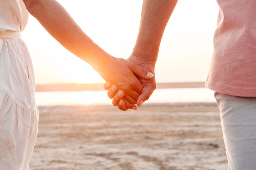 Close up of Couple Holding hands at sunset